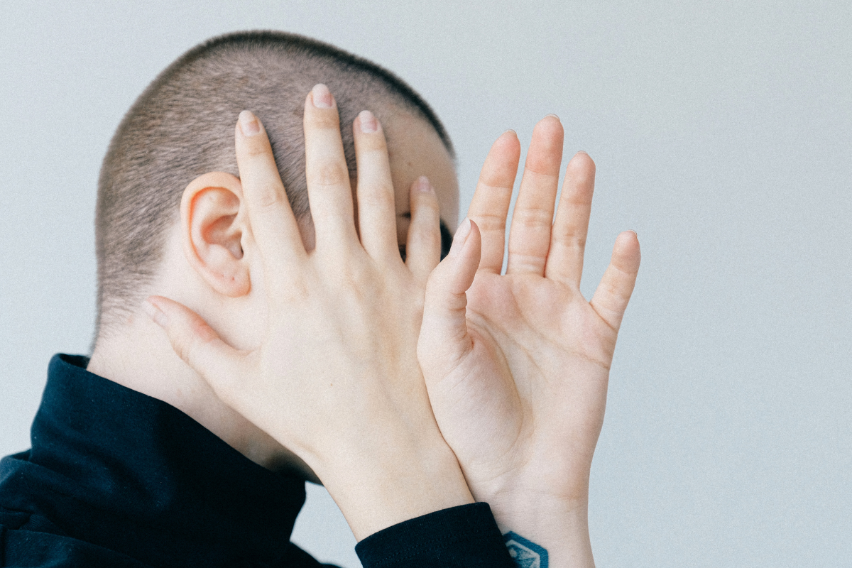 An image of a person covering his face.