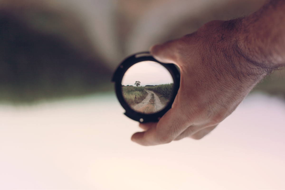 A hand holding a lens to portray focus.
