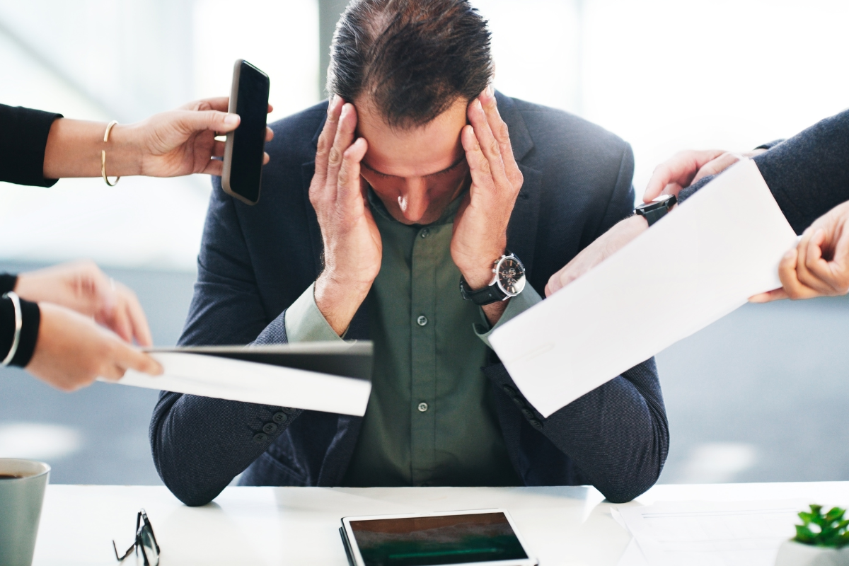 An image of a man bombarded with tasks.