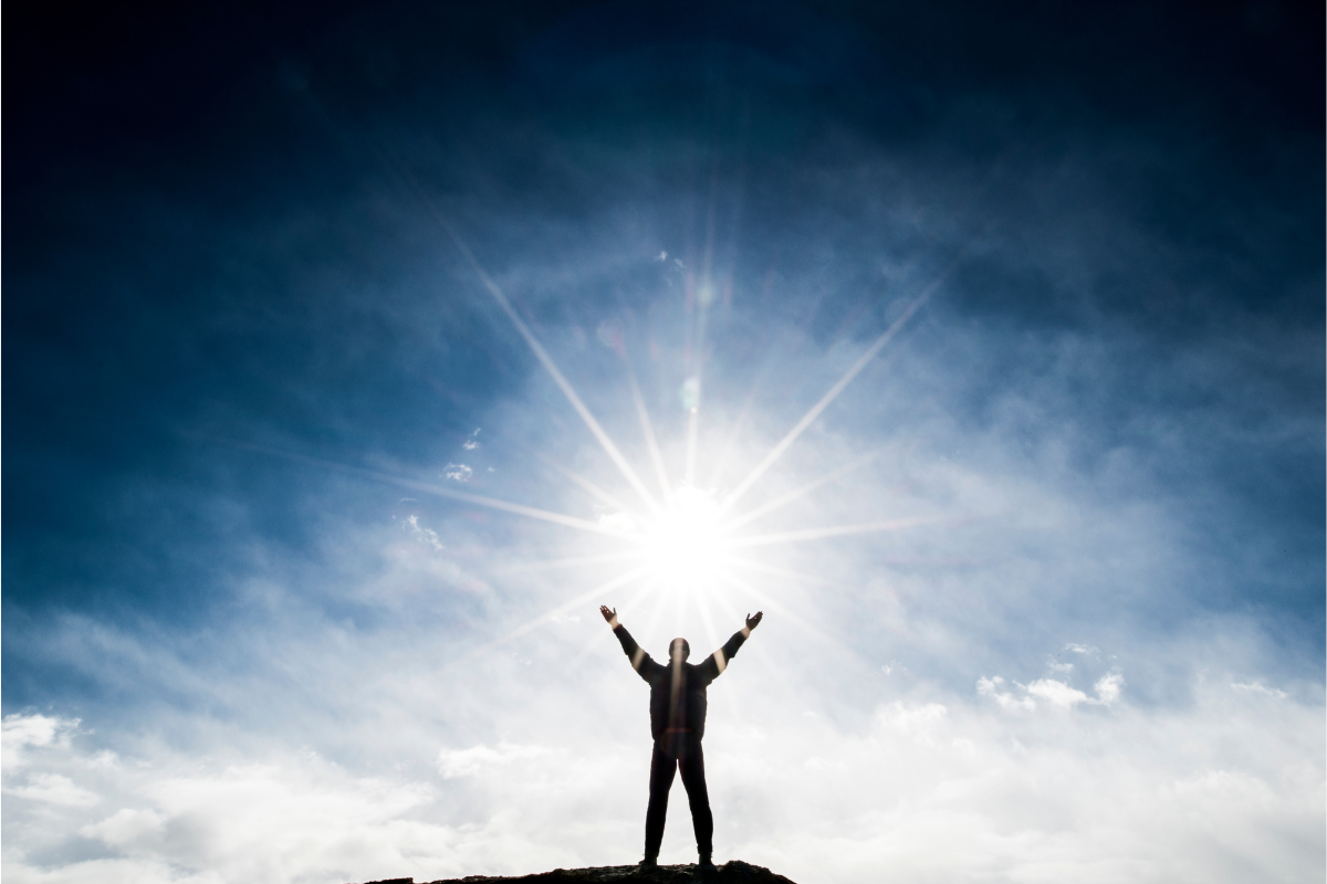 A silhouette of a man with a light shining on him.