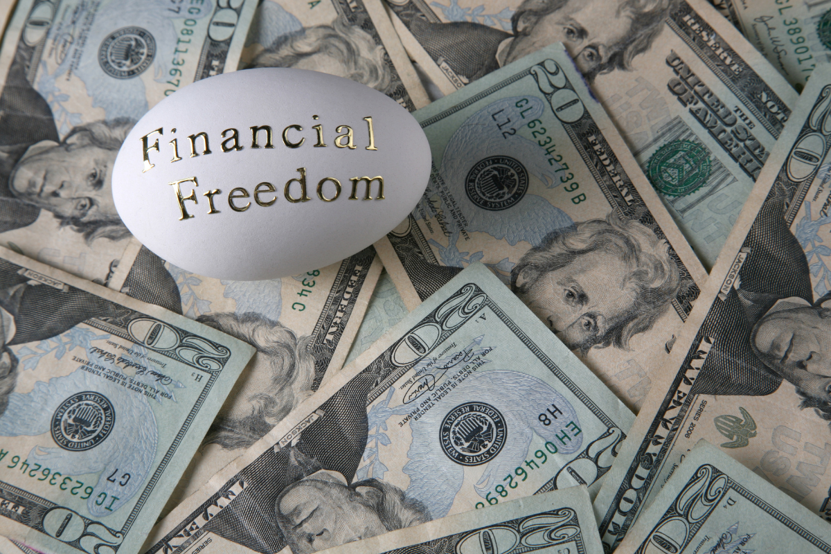 An egg on top of 20-dollar bills with the words Financial Freedom.