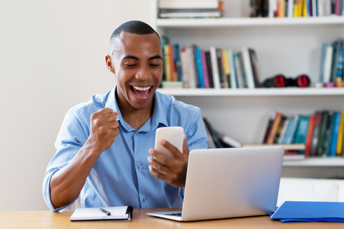 A happy man looking at his cellphone.