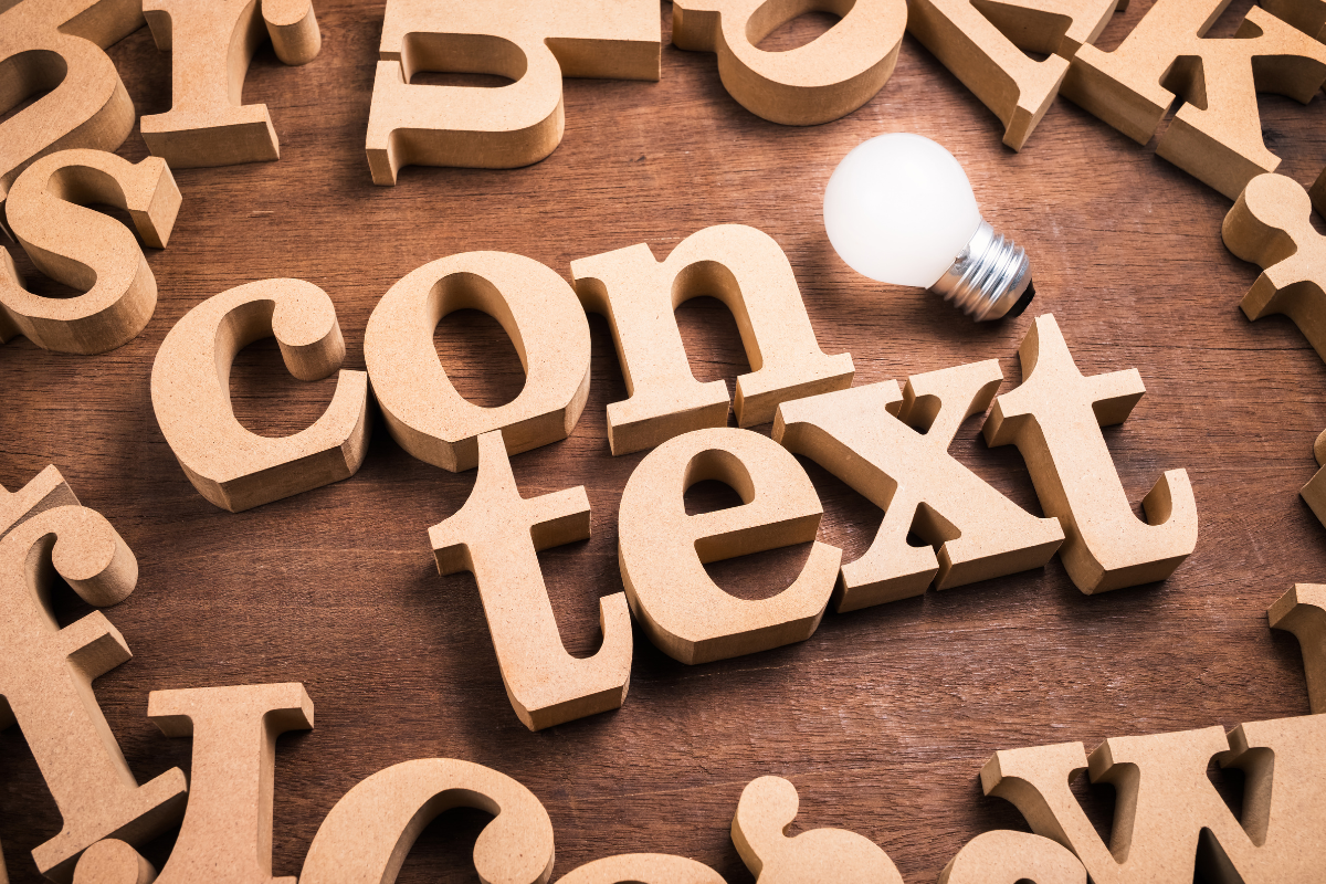 Wooden letters, spelling out the word CONTEXT, with a light bulb on the side.