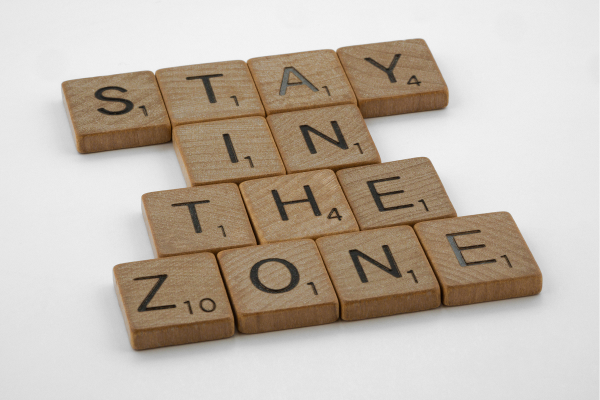 Scrabble tiles spelling out the phrase "Stay in the Zone".
