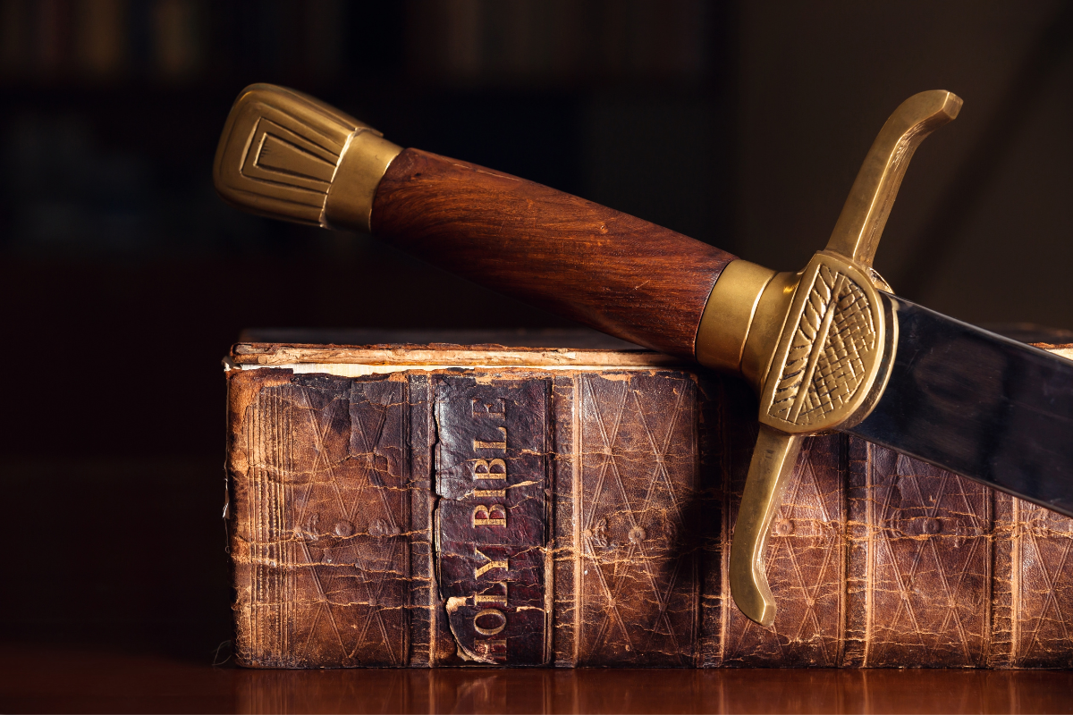 An image of an old Holy Bible and sword.