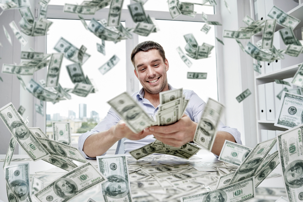 A man surrounded with flying hundred dollar bills.