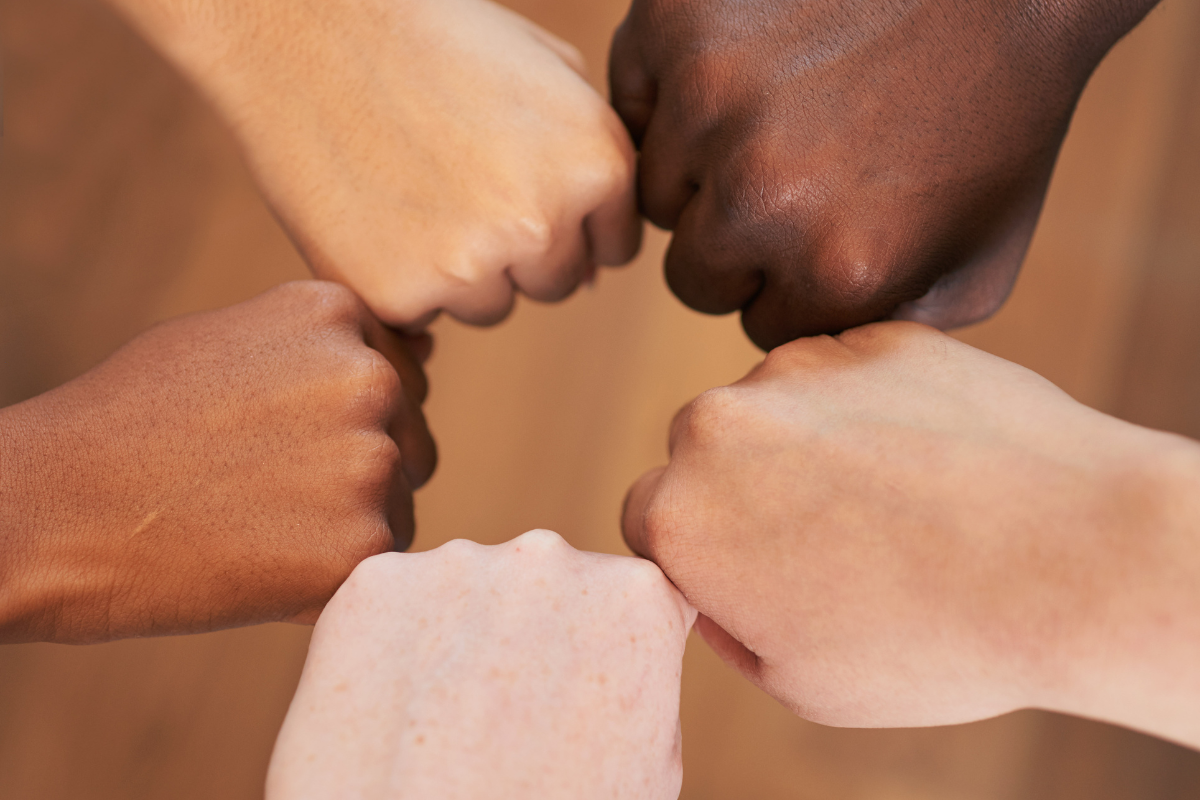 An image of clenched fists with different skin tones.