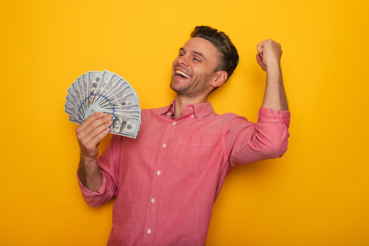 A man happily holding hundred dollar bills.