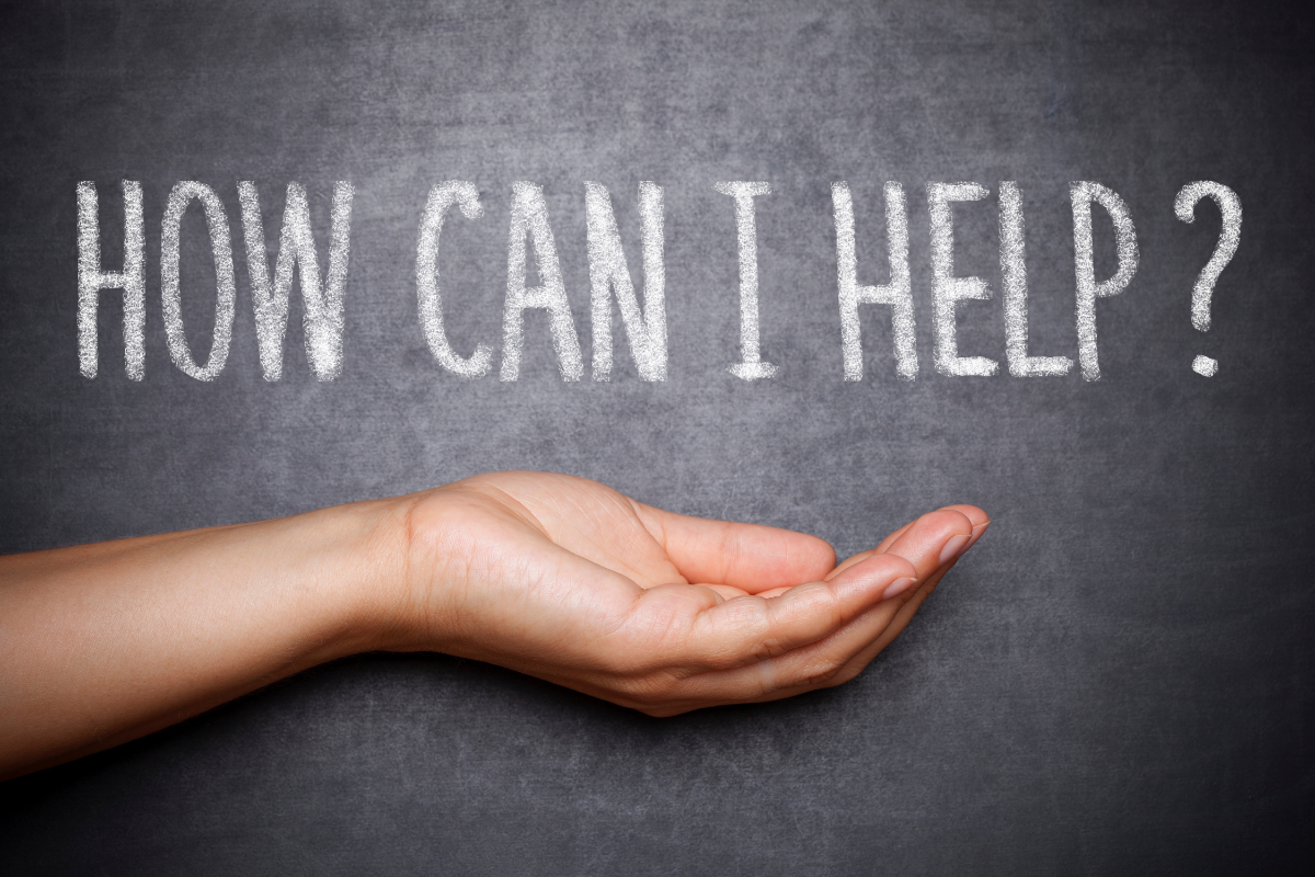 The words How Can I Help? on a black board.