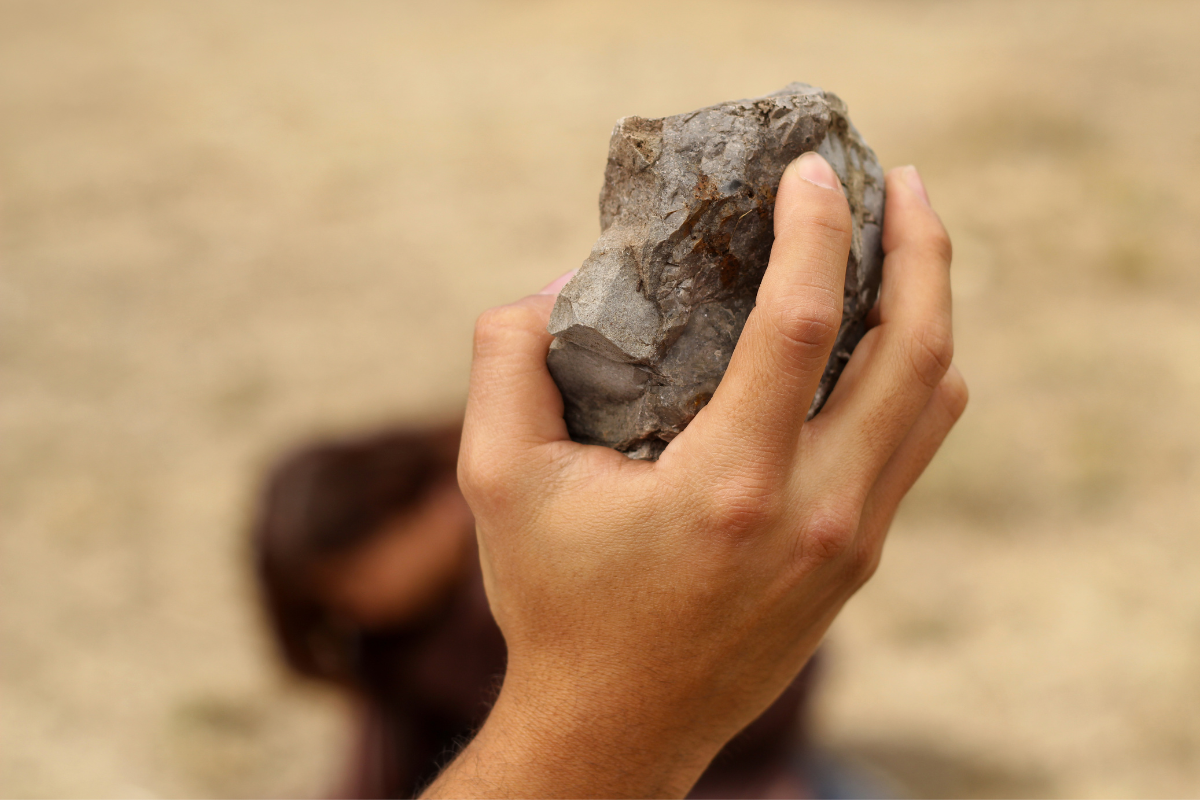 In the act of throwing a big rock.