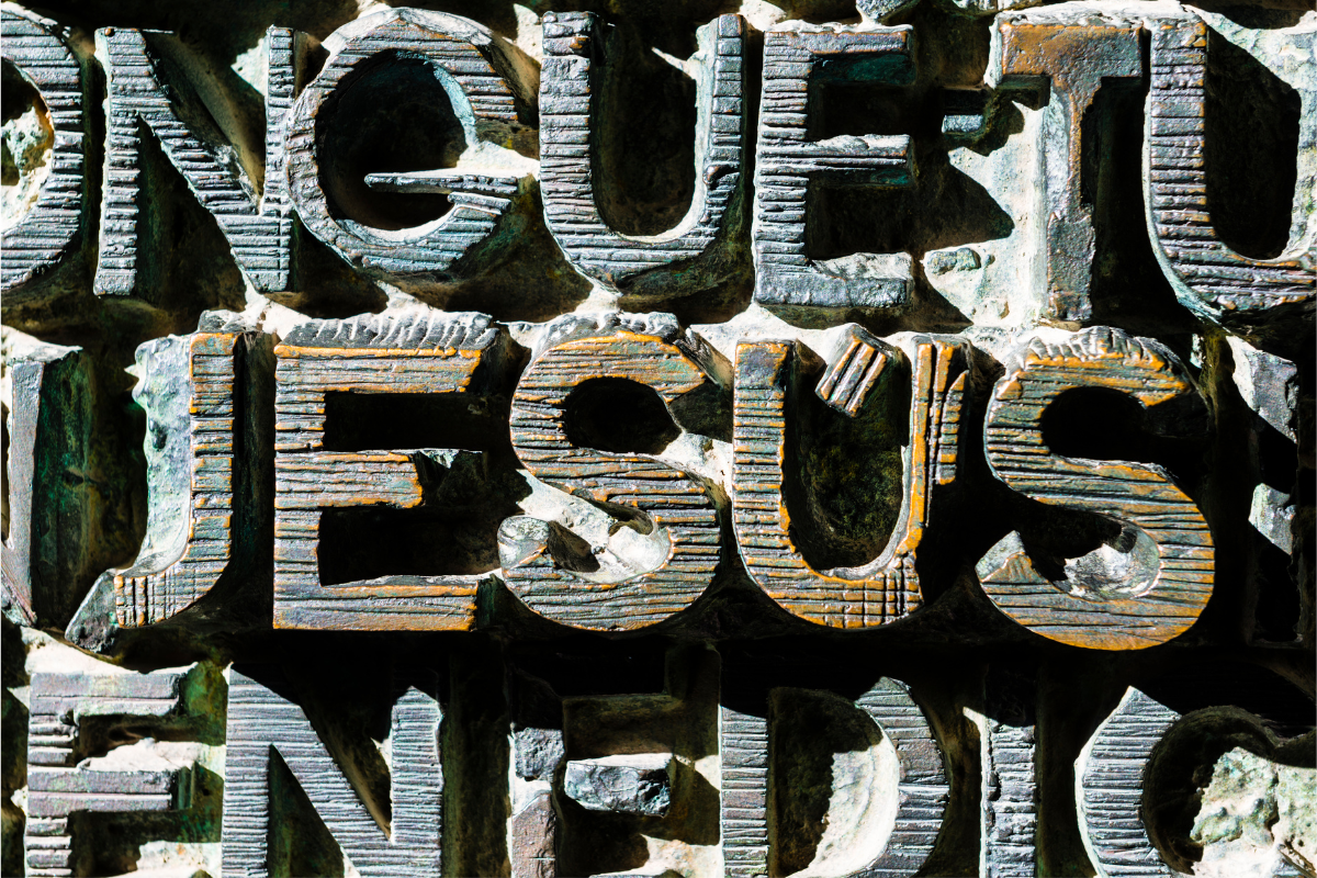 The name of Jesus carved on wood.