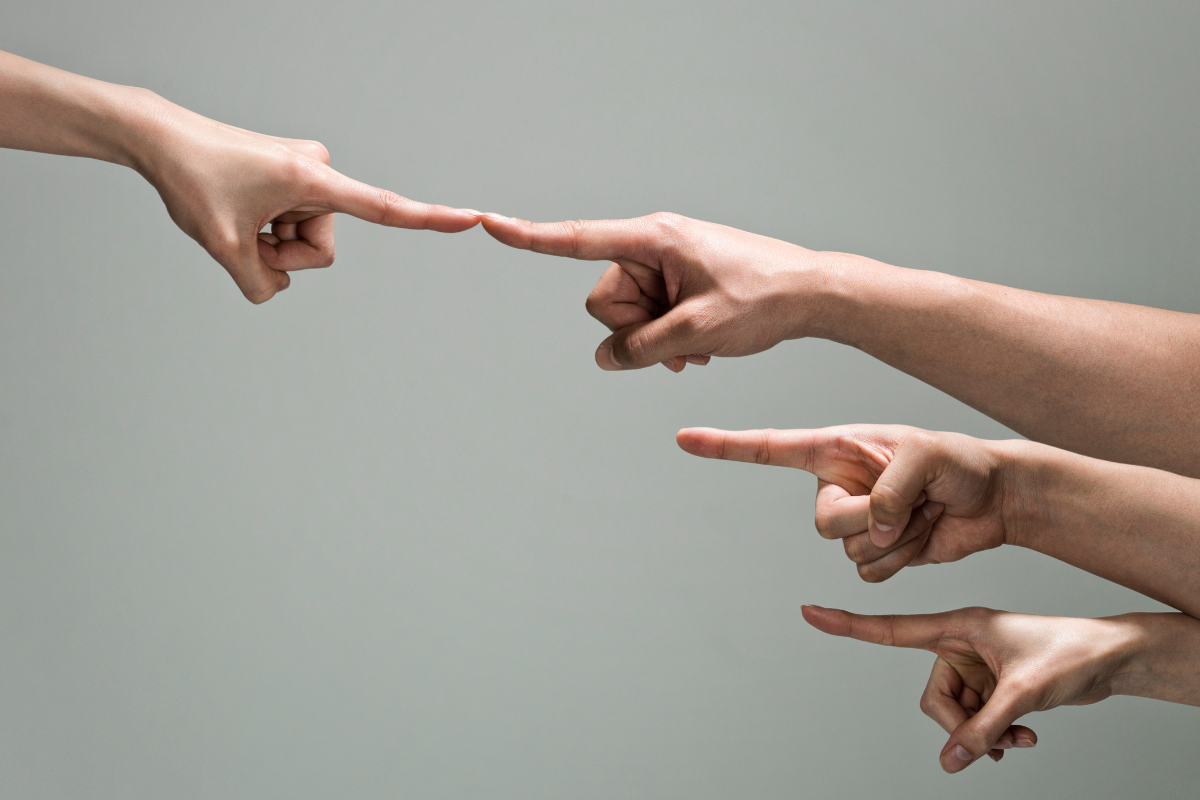 A group of pointing hands with one pair connecting.