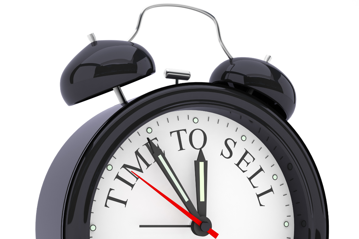 A clock ticking with the words TIME TO SELL on its clock face.