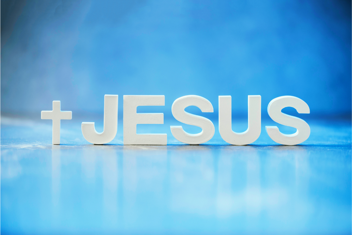 The name Jesus and a cross against a sky blue background.