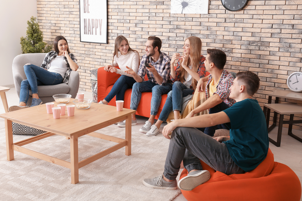 An image of a group of young people discussing in a lobby room.