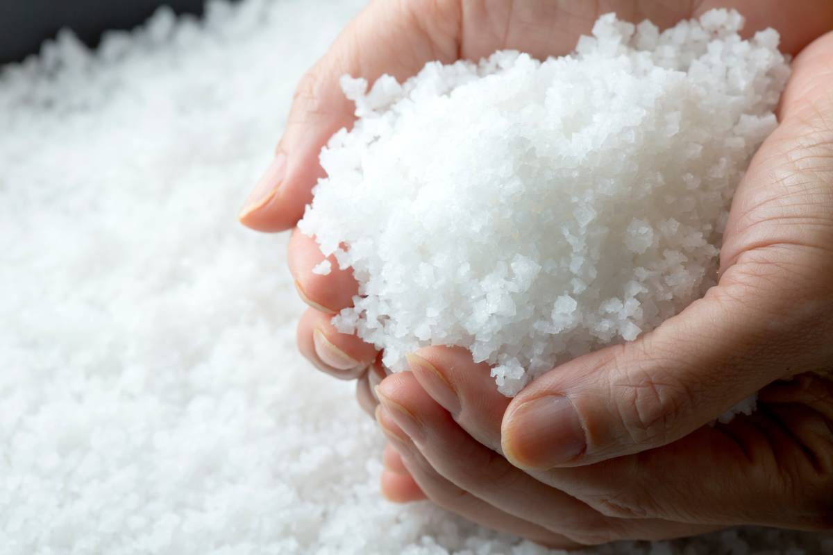 A person holding a handful of salt.