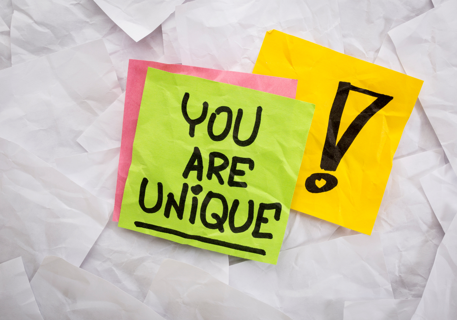 A sticky note with the words YOU ARE UNIQUE!