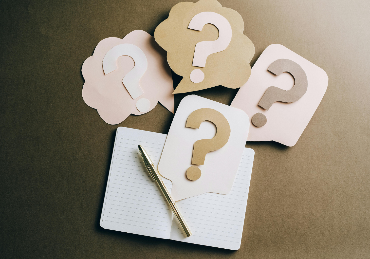 Paper cutouts of question marks.