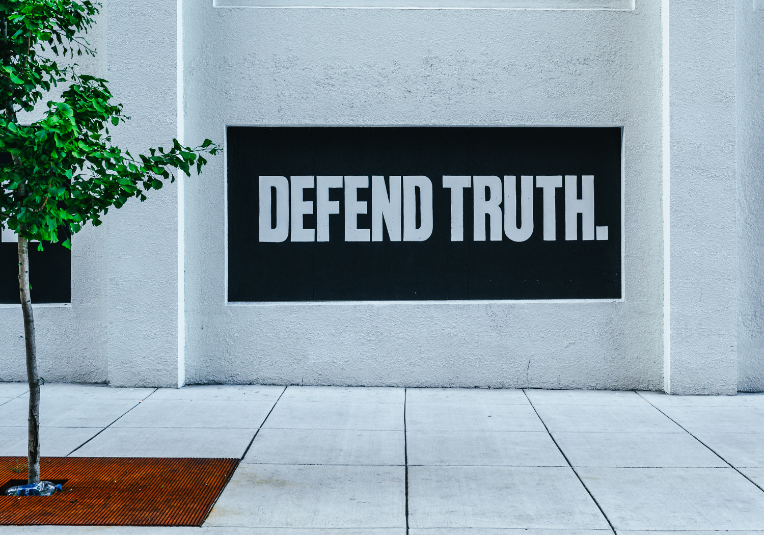 A wall signage that says "Defend Truth".