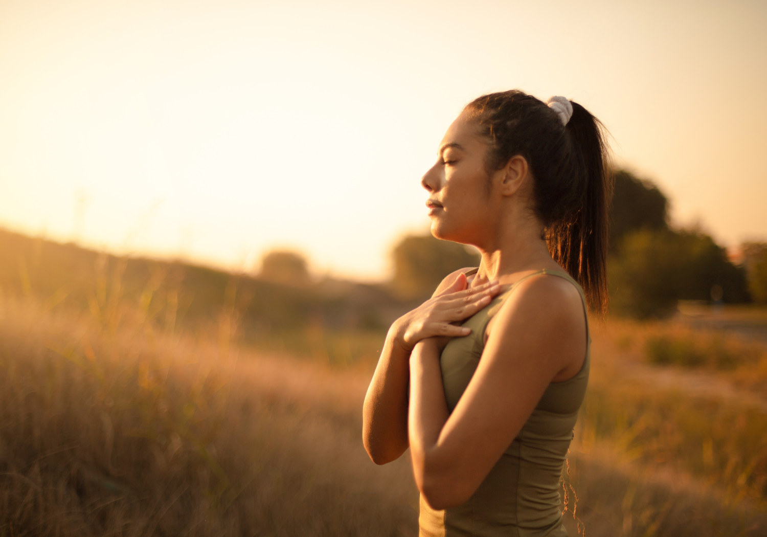 A woman relaxing and breathing in air during a morning jog or walk.