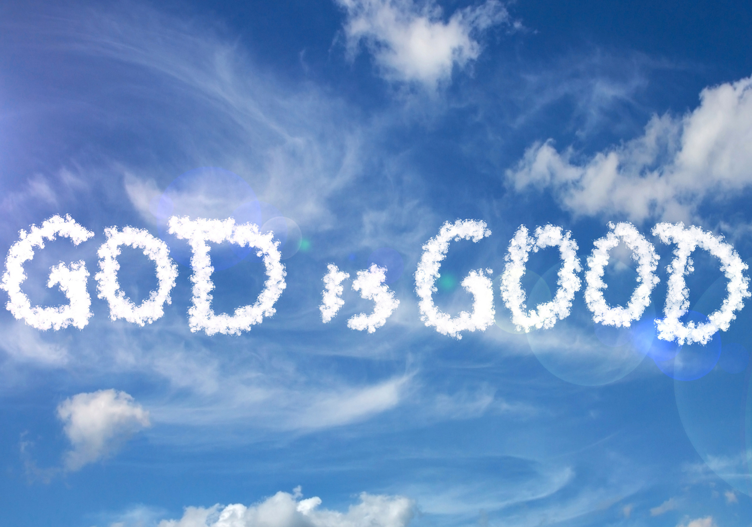 The phrase 'God is Good' spelled in clouds in a blue sky.