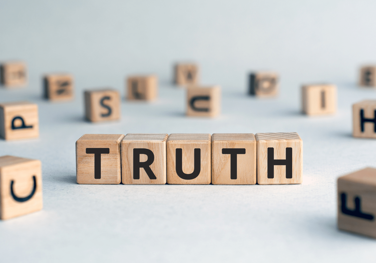 The word TRUTH spelled with wooden cubes.