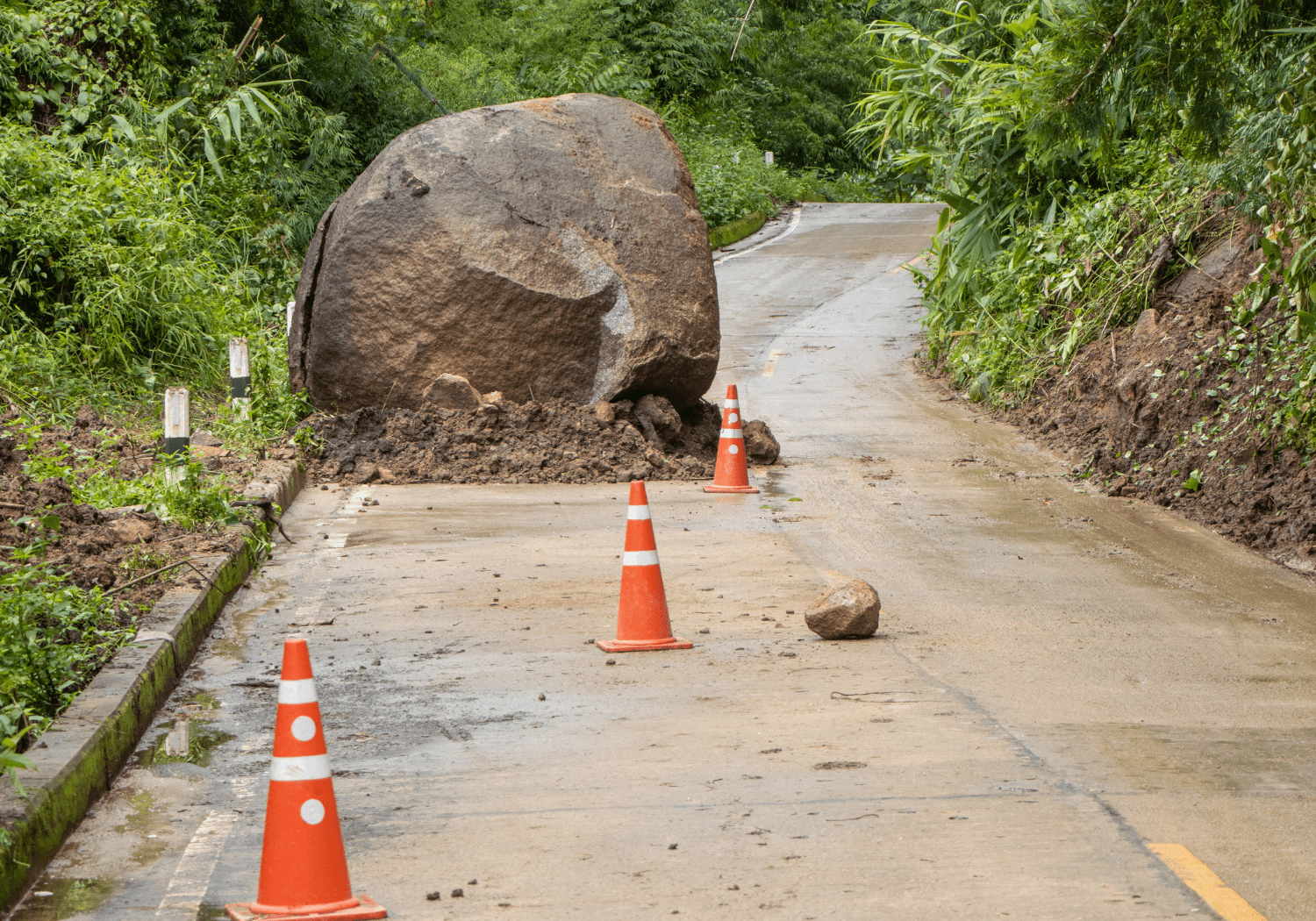 A big boulder blocking one side of the road.