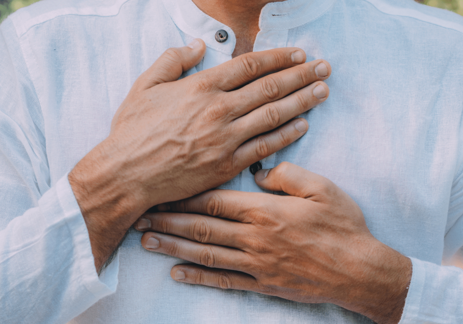 A person putting both his palms on his chest.