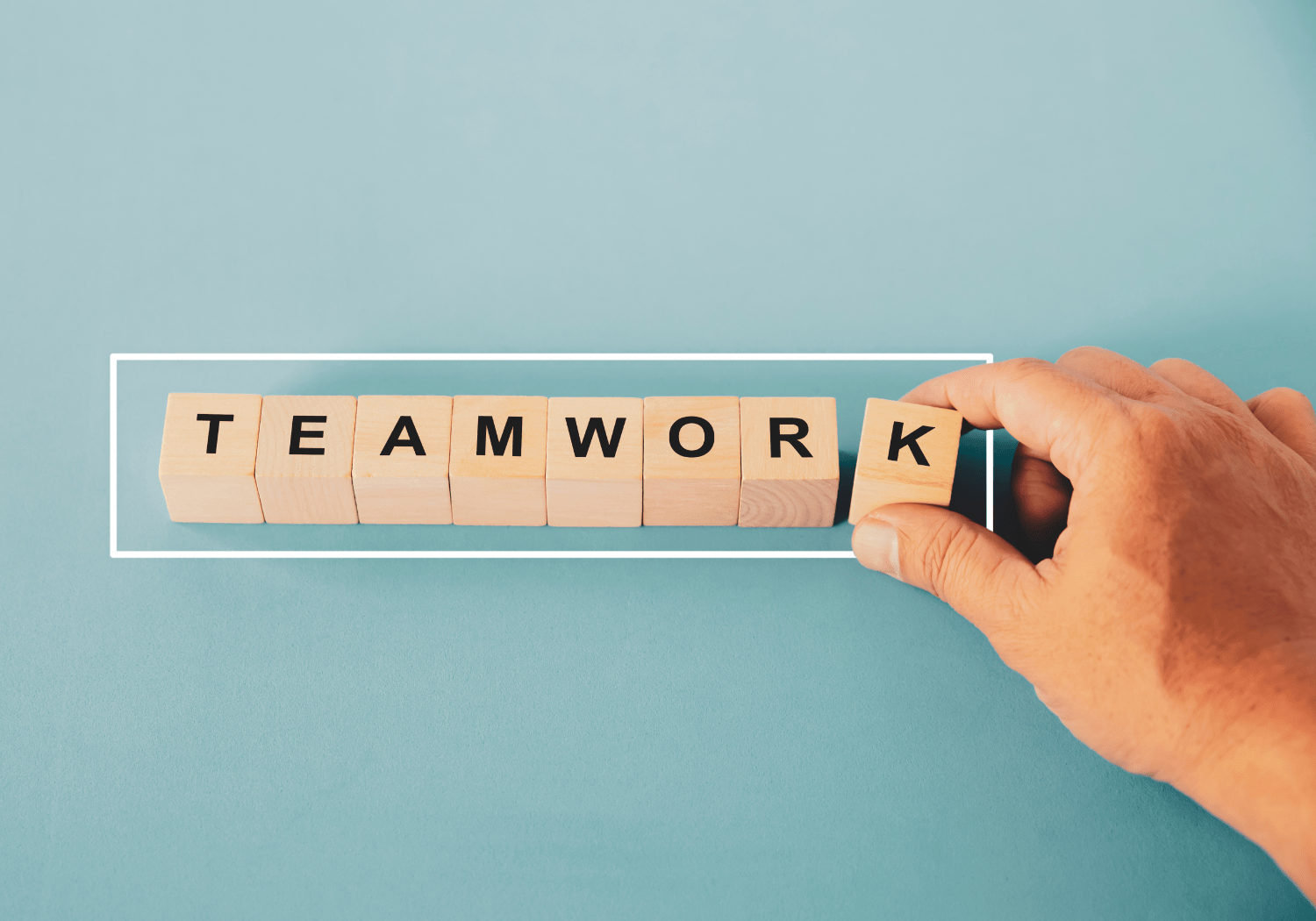 The word TEAMWORK spelled out using wooden cubes.