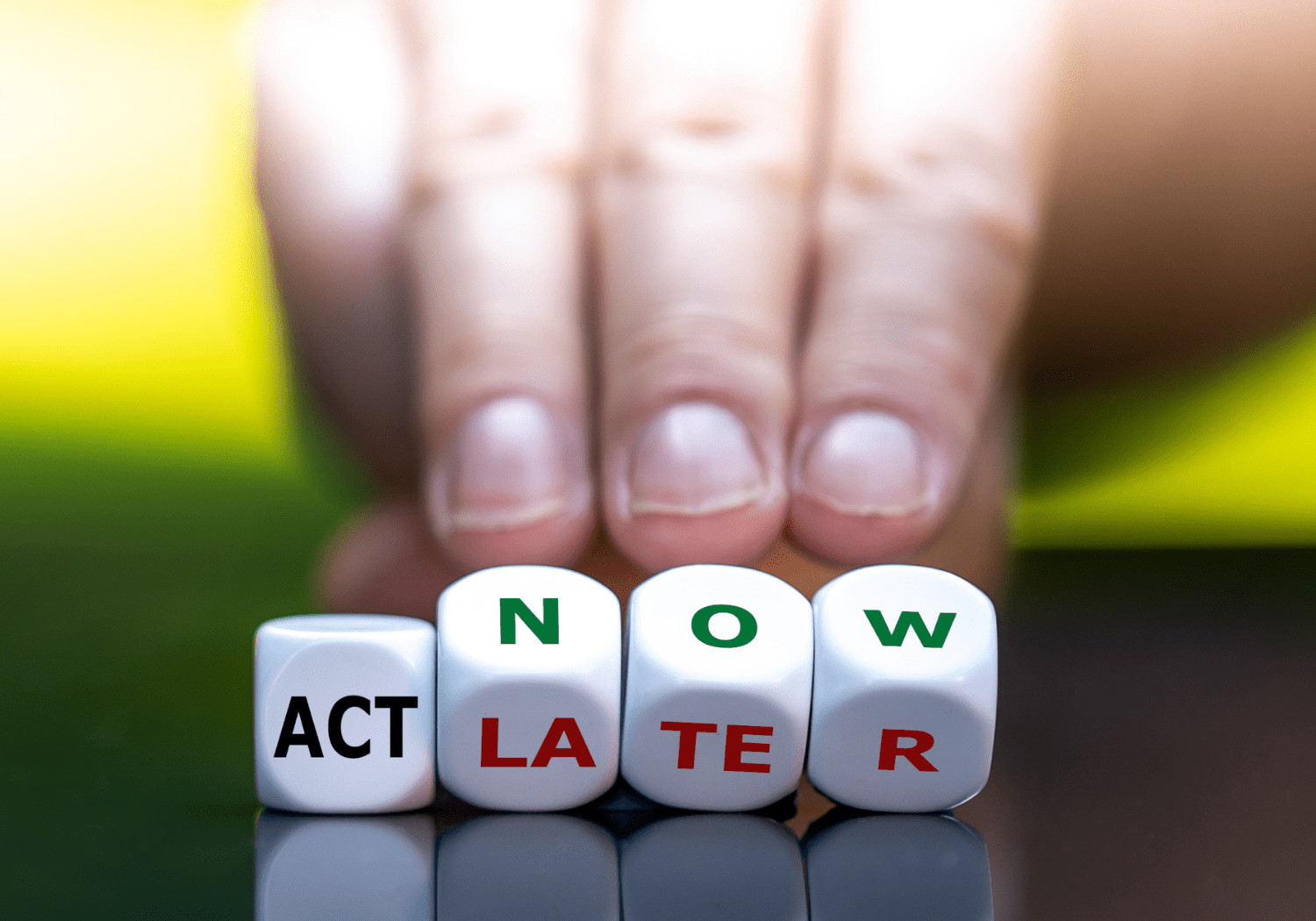 Letter cubes spelling out the words ACT, LATER, and NOW.