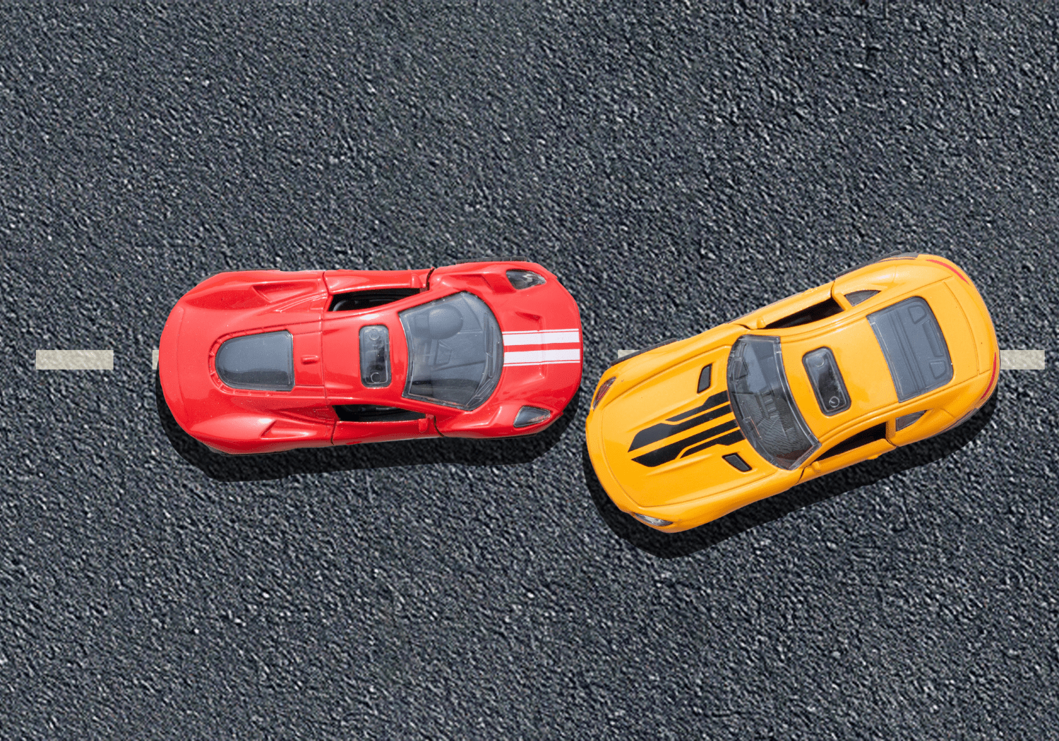 A red and yellow toy car heading on the same direction.