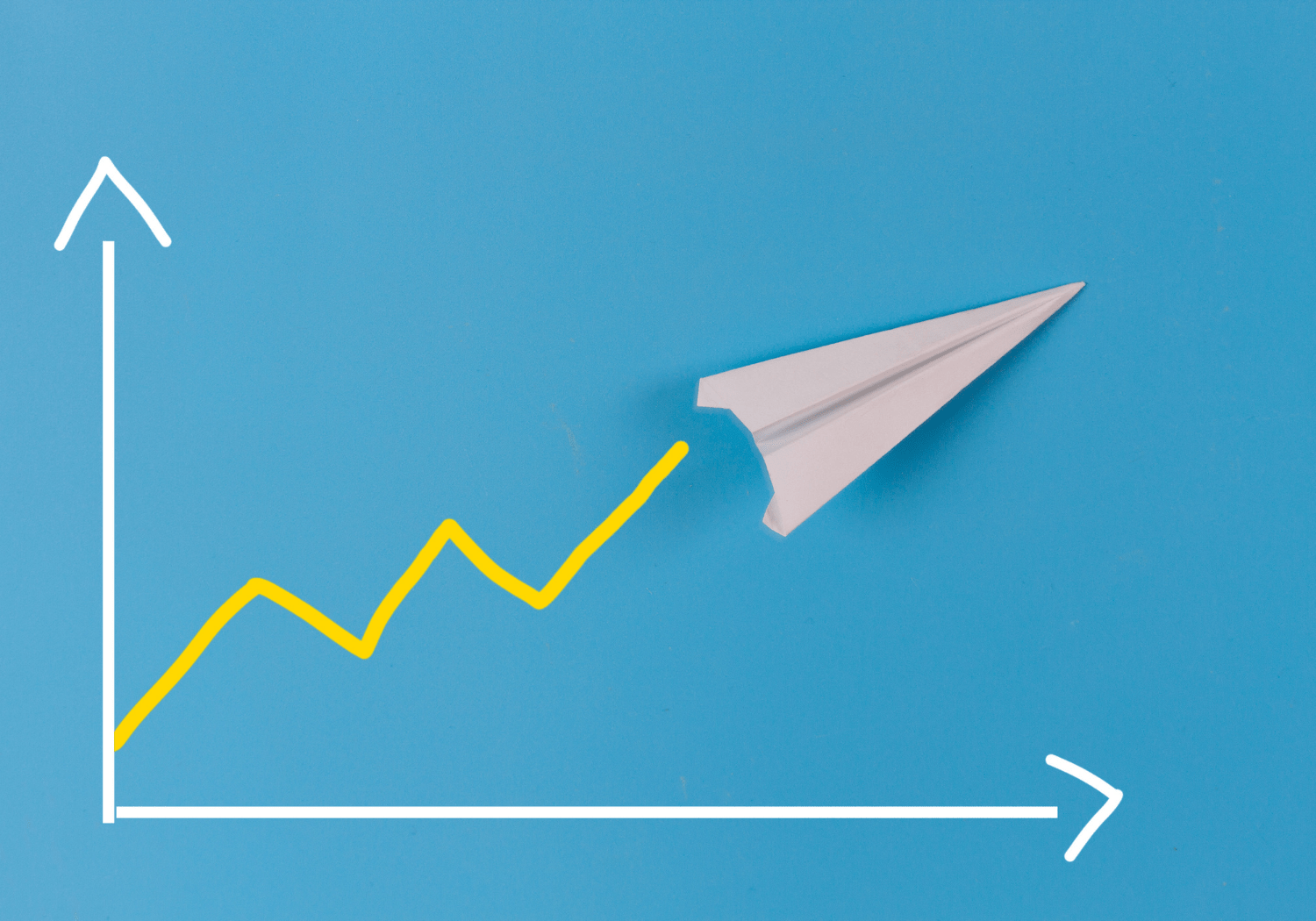 A paper plane moving upward a chart.