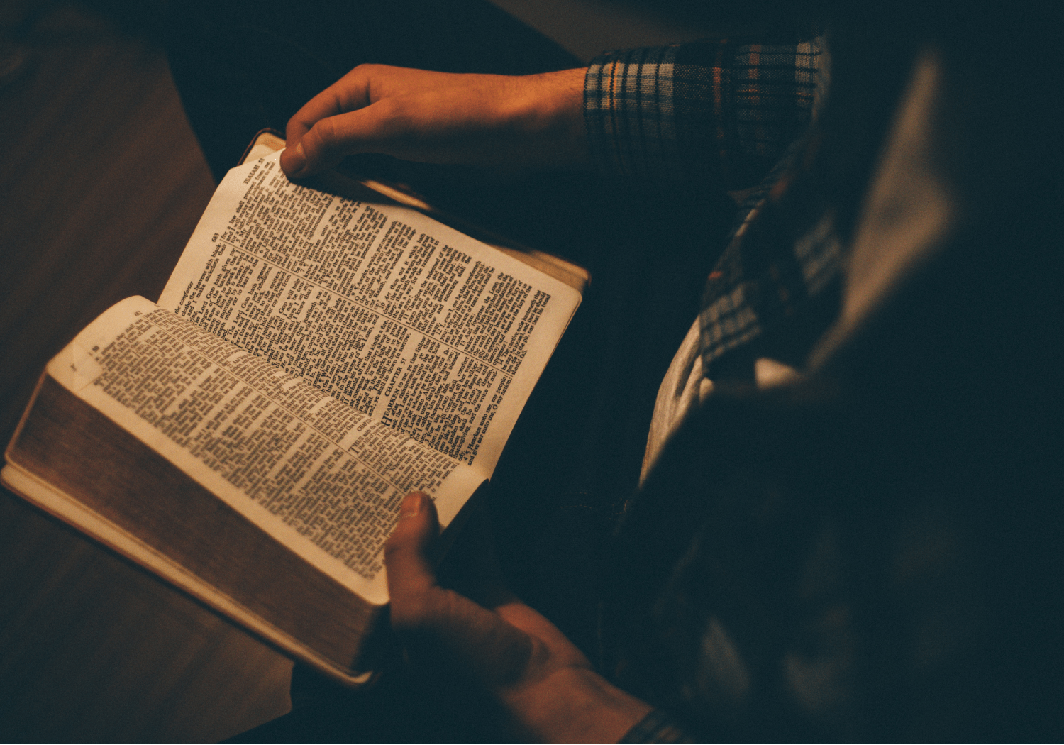 A person holding and reading the Holy Bible.
